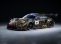 A sleek Porsche 911 GT3 R race car with a gold and black camouflage design is displayed on a dark background. It features a prominent rear wing, the number 91, and several sponsor logos, capturing the spirit of Spa racing.