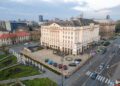 Aerial view of a large, historic hotel building with a courtyard, surrounded by roads and greenery. This urban landmark, once the starting point for the famous Trailblazers Tour, is nestled among other buildings in the vibrant cityscape.