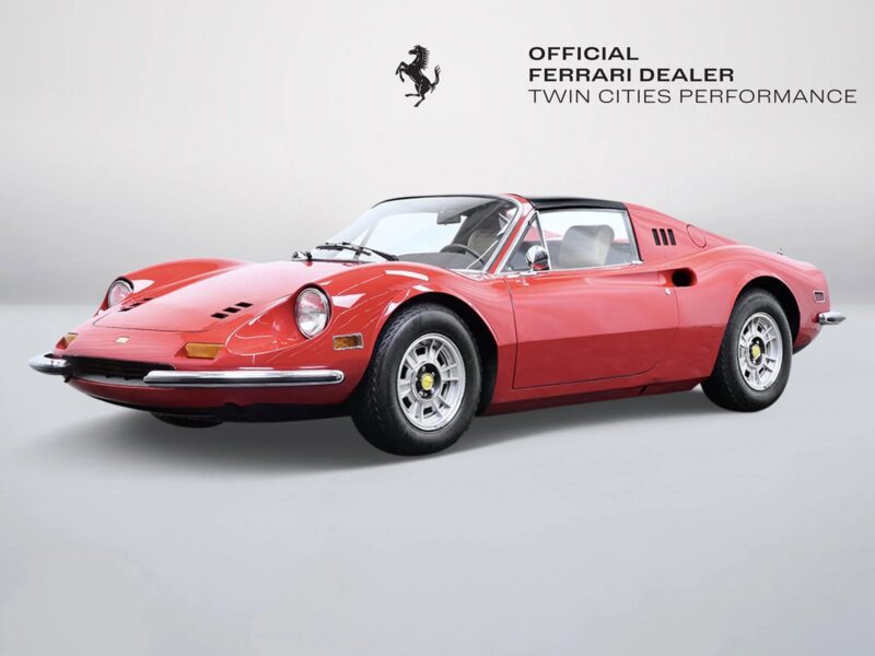 A classic red Ferrari Dino 246 GTS sports car is displayed in a studio setting, highlighting the elegance of Ferrari Dino cars for sale, with "Official Ferrari Dealer Twin Cities Performance" text and logo in the background.