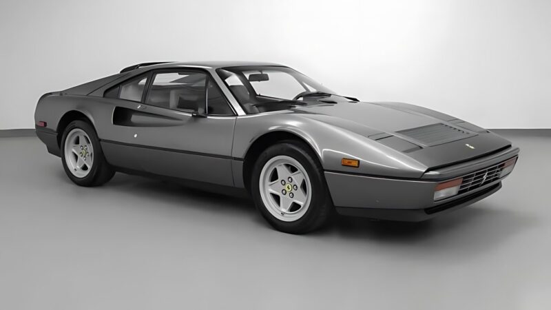 A gray Ferrari 328 GTS two-door sports car, featured as one of the best supercars under $200k, is parked in a plain, white indoor studio.