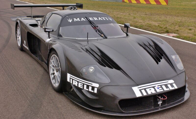 A black Maserati race car with Pirelli branding is parked on a racetrack, featuring aerodynamic bodywork and a prominent rear wing—reminiscent of the exclusive 10 Enzo Derivates That Only REAL Ferrari Fans Know About.