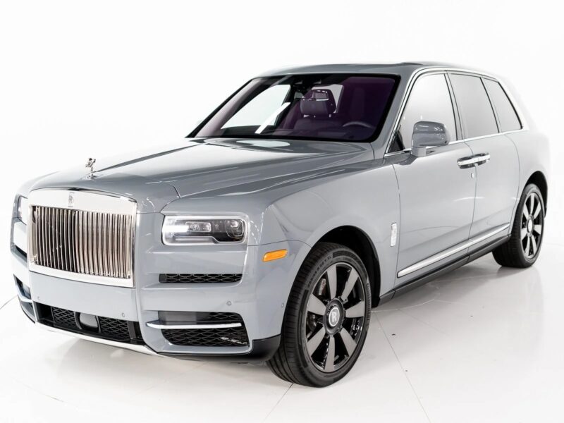 A silver Rolls-Royce Cullinan, the pinnacle of luxury SUV design, is parked on a white background and viewed from the front left side.
