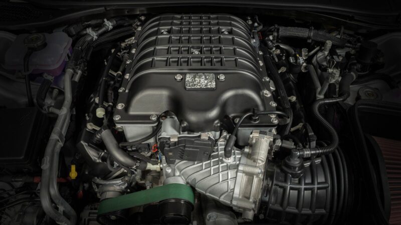 Close-up view of a high-performance 2023 Dodge Challenger SRT Demon 170 engine with visible supercharger, belts, hoses, and detailed mechanical components—a crown jewel no MOPAR collector can ignore.