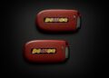Two red key fobs with “DEMON” written on them are placed on a dark surface, one above the other—perfect for any 2023 Dodge Challenger SRT Demon 170 enthusiast or MOPAR collector.