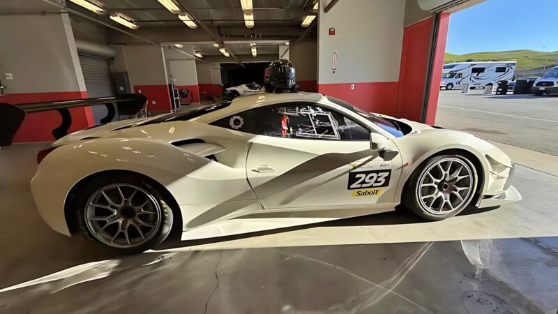 A white race car with the number 293 is parked inside a garage with open doors, sunlight streaming in—an exciting find for anyone seeking top options in the For Sale: Best Supercars Under $200k category.