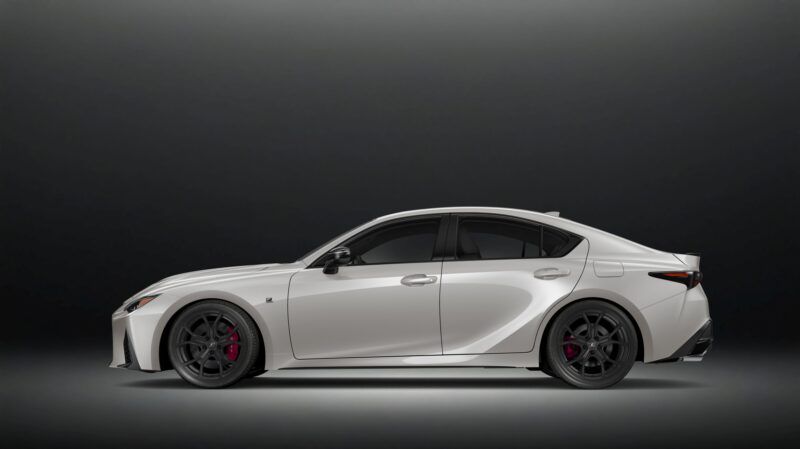 A white Ultimate Edition: Last-Surviving V8 compact luxury sedan with black alloy wheels and tinted windows, shown in profile view against a dark gradient background, updated for 2025.