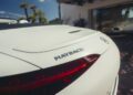 Close-up of the rear of a white 2026 Mercedes-Maybach SL 680 convertible, showing the Maybach badge and part of a red tail light—soon to be available at select US dealers.