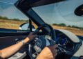 Cruising through Portugal in a luxury Bugatti convertible on a sunny day, hands gripping the wheel and dashboard instruments gleaming—an unforgettable Grand Tour 2025 experience.