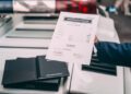 A person holds a certificate of authenticity above the rear of a white Lamborghini, with police lights and open document folders visible in the background—capturing a striking moment reminiscent of FuoriConcorso at Villa d'Este.