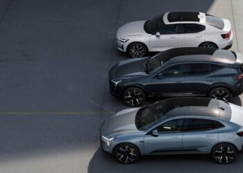 Three silver, black, and white electric cars are parked side by side in a lot, viewed from above.
