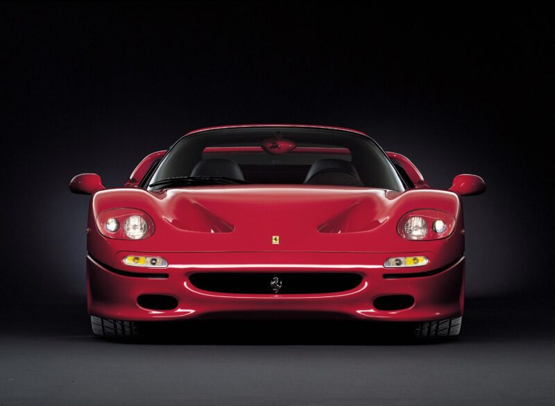 Front view of a red Ferrari F50 sports car against a black background, celebrating its 30th Anniversary on the Legacy Tour.