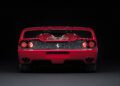 Rear view of a red Ferrari F50 sports car with dual exhausts, round tail lights, and a prominent rear wing, photographed against a black background—perfect for celebrating the 30th Anniversary Legacy Tour.