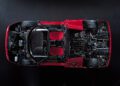 Top-down view of a red Ferrari F50 with its body partially removed, revealing interior seats, dashboard, steering wheel, and detailed engine—perfect to celebrate the 30th Anniversary Legacy Tour.