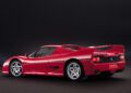 A red Ferrari F50 sports car is shown from the rear side angle against a plain dark background, capturing the spirit of Tuscany on a Legacy Tour.