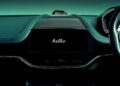 Car dashboard with a central touchscreen displaying "hello" in white text; steering wheel and part of an instrument panel visible on the right, showcasing Aston Martin as the first automaker to debut Apple CarPlay Ultra.