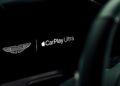 Close-up of a car display screen showing the Aston Martin logo and the text "Apple CarPlay Ultra" as Aston Martin becomes first automaker to debut Apple CarPlay Ultra.