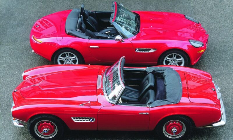 Two red convertible sports cars parked side by side, viewed from above; one is classic with chrome details—showing how this BMW went from bold gamble to blue-chip classic—the other is modern with silver wheels.
