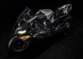 A black Carbon-Clad Concept BMW Motorrad sport motorcycle with yellow accents, viewed from above against a dark background, showcases the next generation of RR design.