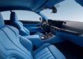 Interior view of a modern Zagato car with light blue leather seats, blue upholstery, a digital dashboard, and a central console with controls, embodying the elegance of a Bavarian-Italian GT.