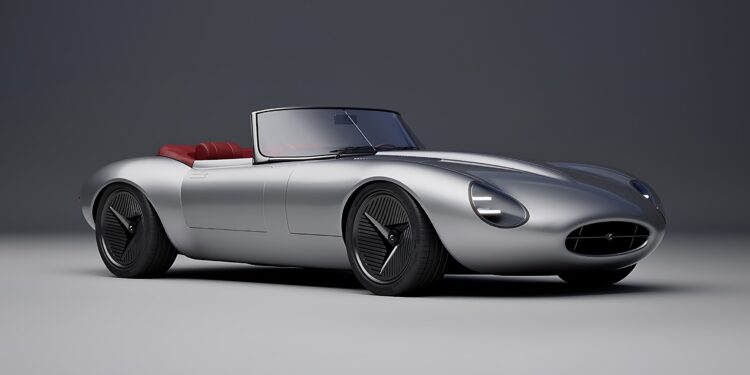 A silver convertible sports car with a sleek, aerodynamic design and red interior, shown in a studio setting—reminiscent of how former Jaguar designer Ian Callum reimagines a modern-day E-Type.