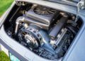 Close-up view of a classic car's engine bay with a horizontally opposed engine and fan, seen through an open rear hood at the Classic 9 Motorwerks Celebration Exotic Car Festival.