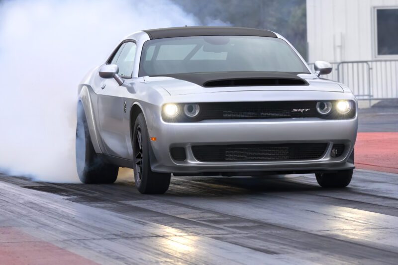 A silver 2023 Dodge Challenger SRT Demon 170 performs a burnout on a drag strip, smoke billowing from the rear tires—a crown jewel no MOPAR collector can ignore.