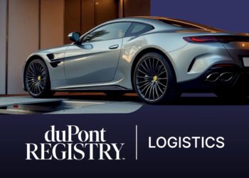 A silver luxury sports car is being loaded into a white transport trailer, showcasing premium vehicle logistics. The duPont REGISTRY Logistics logo appears prominently in the foreground.