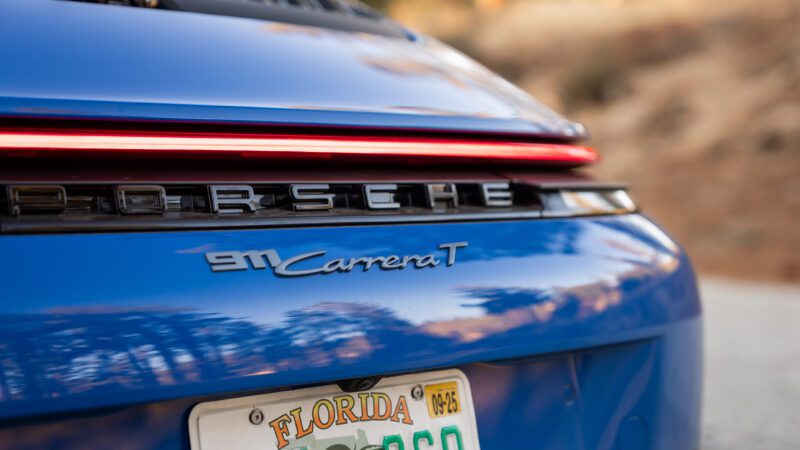 Close-up of the rear of a blue Porsche 911 Carrera T with a Florida license plate and Porsche badging visible.