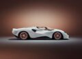 A white, modern De Tomaso P72 sports car with a sleek, aerodynamic design is displayed in a studio setting with a brown gradient background.