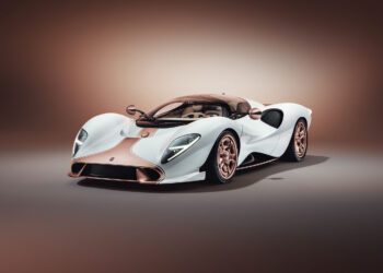 A white and rose gold De Tomaso P72 luxury sports car with a sleek, aerodynamic design is displayed in a studio setting with a neutral background, showcasing its production-spec elegance.