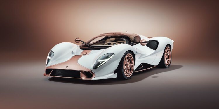 A white and rose gold De Tomaso P72 luxury sports car with a sleek, aerodynamic design is displayed in a studio setting with a neutral background, showcasing its production-spec elegance.