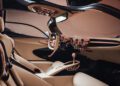 Luxurious car interior with beige and copper accents, featuring leather seats, a sleek steering wheel, round air vents, and a modern dashboard inspired by the production-spec De Tomaso P72.
