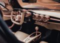 Close-up interior view of the production-spec De Tomaso P72, featuring tan leather seats, a unique steering wheel, and multiple metallic circular air vents on the dashboard.