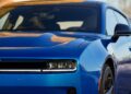 Close-up of the front and side of a blue Four-Door Dodge Charger Daytona, showcasing its headlight, grille, hood, and part of the windshield—there's more to this muscle car sedan than meets the eye.