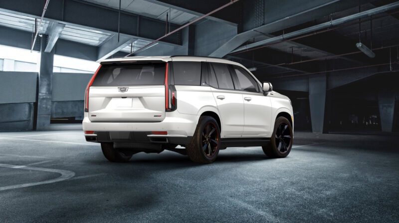 A white SXR Series SUV with black wheels is parked in an empty, dimly lit parking garage.