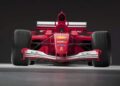 Red Formula 1 race car viewed from the front, displaying sponsor logos and wide tires, reminiscent of the Ferrari F2001 that set records at the Historic Monaco Sale as the most valuable Schumacher-F1 car auctioned at €15.98 million.
