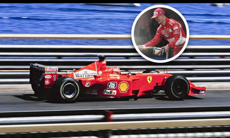 A red Ferrari Formula 1 car races on track near water; inset shows a driver celebrating with champagne—capturing the excitement of the Historic Monaco Sale, where the Ferrari F2001 became the most valuable Schumacher-F1 car at €15.98 million.