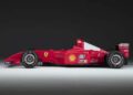 Side view of a red Formula 1 race car featuring sponsor logos, Ferrari emblem, and the number 1 on the rear wing—echoing the Historic Monaco Sale where the Ferrari F2001 became the most valuable Schumacher-F1 car auctioned at €15.98 million.