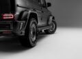 Close-up of the rear and side of a black Mercedes-Benz G-Wagon SUV in a studio setting with a grey background, showcasing its bold Widetrack Aero Kit.