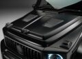Close-up view of the matte black hood and grille of a luxury SUV, featuring distinctive vents, blue-highlighted headlights, and aggressive Widetrack styling inspired by custom G-Wagon aero kits.