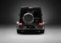 Rear view of a black G-Wagon luxury SUV with a branded spare tire cover, illuminated taillights, and a license plate reading "URBAN," enhanced by Widetrack Aero Kits against a neutral background.