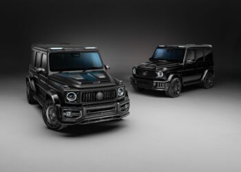 Two black luxury SUVs, including a G-Wagon with Widetrack & Aero Kits, are parked on a smooth, neutral-colored surface in an Urban Automotive-inspired studio setting with soft, even lighting.