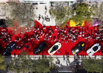 Aerial view of the Miami Concours 2025 event, with luxury cars displayed on a red carpet, surrounded by award winners, guests, and trees on a sunny day.