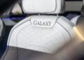 Close-up of a white Bentley Motors car seat with diamond-patterned stitching and "GALAXY" embroidered on the headrest, showcasing the luxury found in bespoke sedans like the Flying Spur Mulliner.