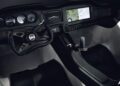 Modern vehicle cockpit featuring a steering wheel, analog gauges, a central digital display showing a map, control buttons, and a black leather seat—resembling the production prototype of Klein Vision AirCar as it breaks cover.