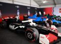Life-sized LEGO F1 cars are showcased indoors under a tent in Miami, with people admiring these drivable life-size LEGO creations in the background.
