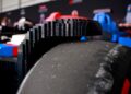 Close-up of a race car tire constructed with LEGO bricks, capturing the textured black tread. This drivable creation is part of the impressive Life-Size F1 Cars series, shown against a blurred background.