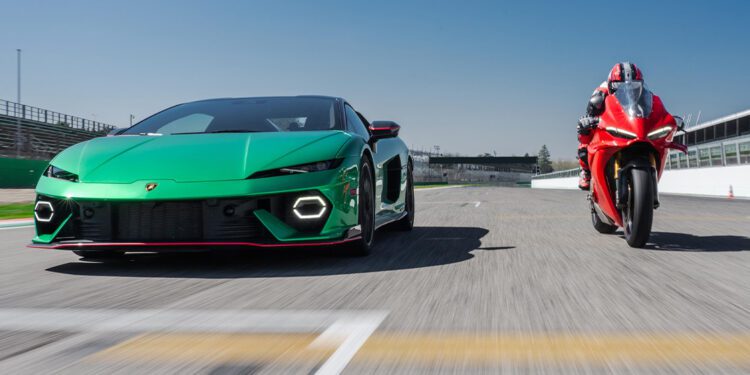 A green Lamborghini Temerario and a red Ducati Panigale V4 drive head-to-head on a racetrack under a clear blue sky.