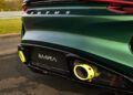 Close-up of the rear of a green Lotus Emira Jim Clark Edition sports car, showing the dual yellow exhaust tips and Emira badging on the license plate area, celebrating its exclusive 1-of-60 status.