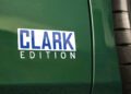 Close-up of a green Lotus Emira Jim Clark Edition vehicle, featuring a "CLARK EDITION" decal in white and blue lettering near the rear wheel; this exclusive model is part of a rare 1-of-60 production run.